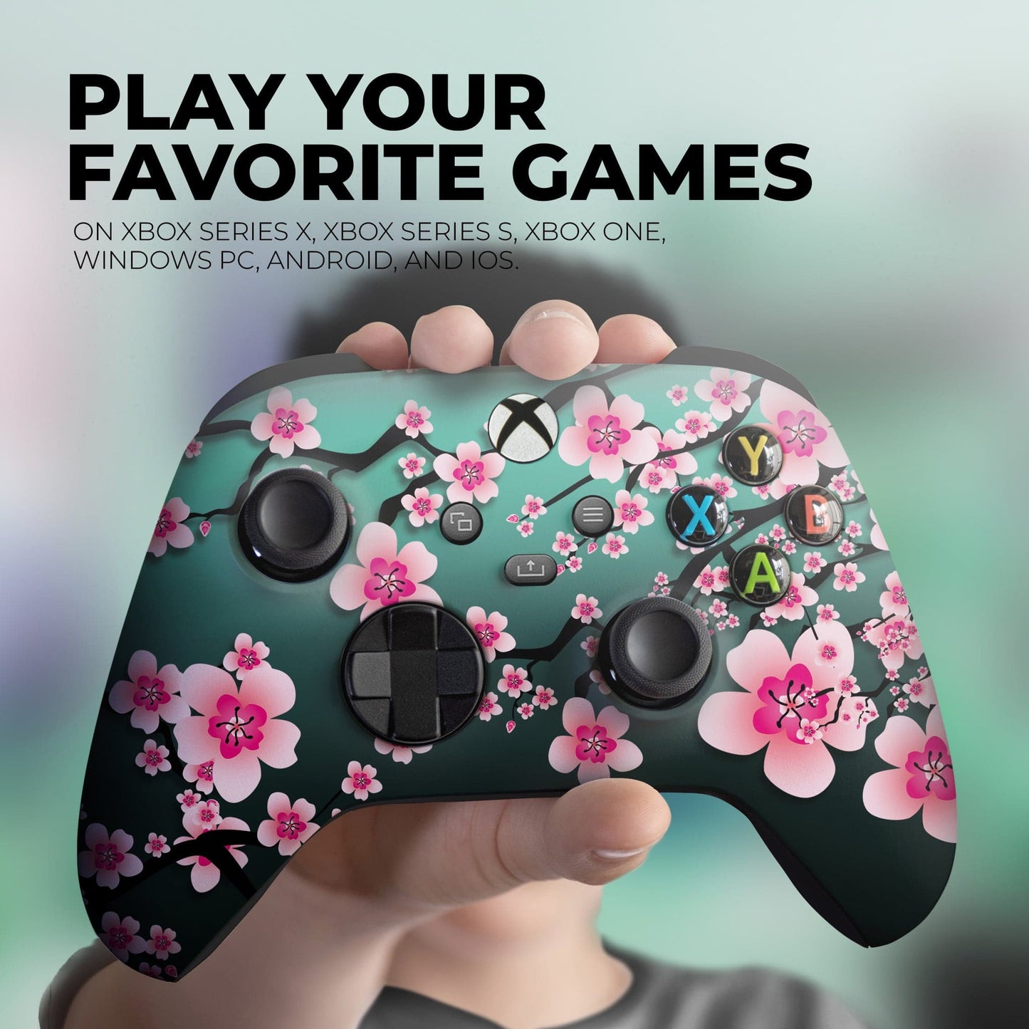 Teal game controller with pink cherry blossom floral print, held front view