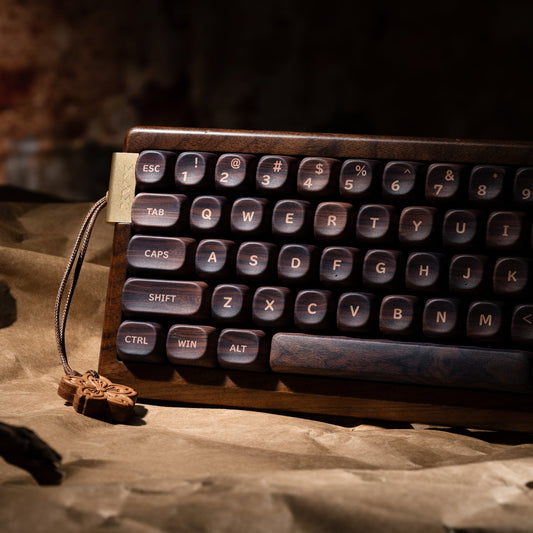 Wireless mechanical keyboard angled view with mixed keycaps and attached wooden flower charm