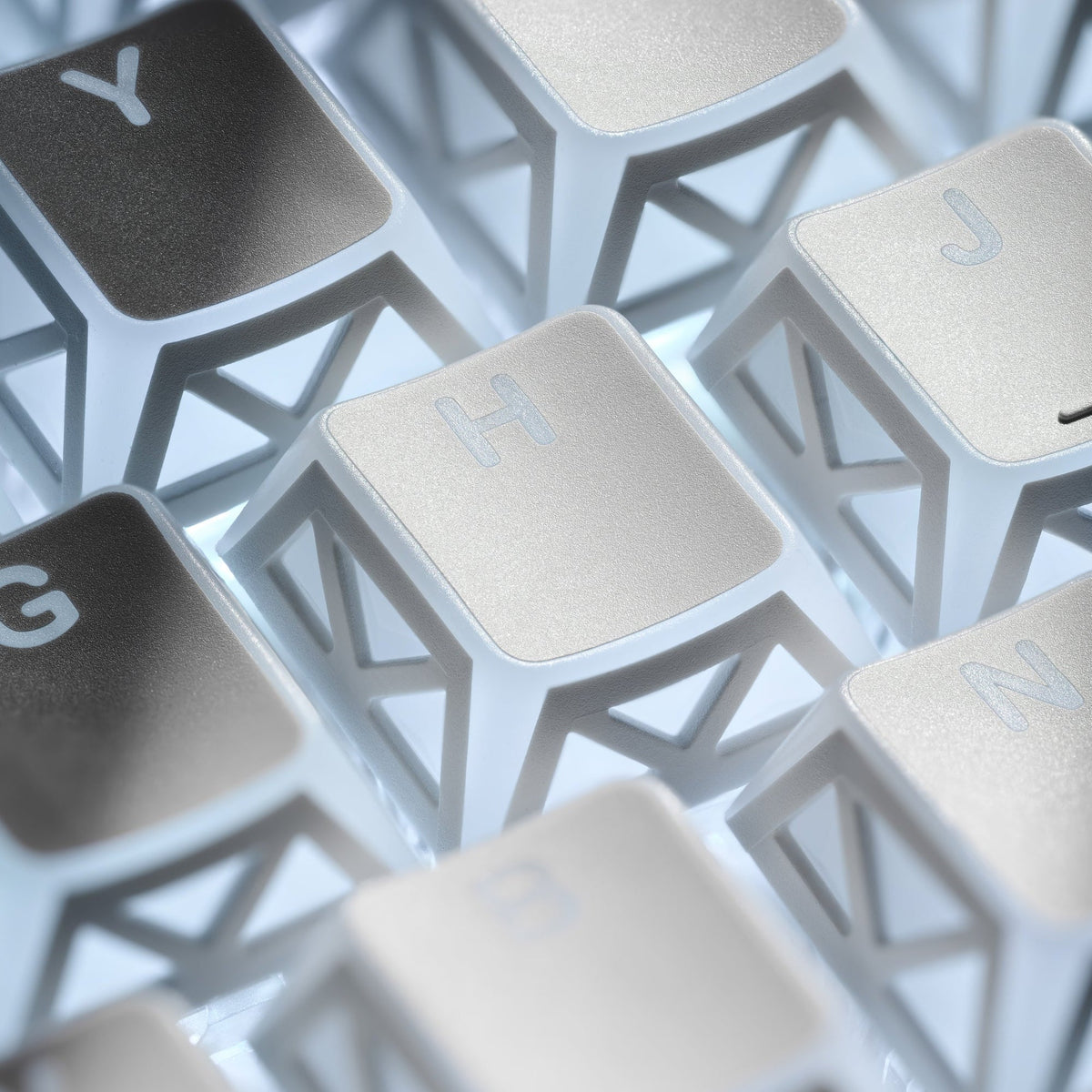 White PBT keycap close-up with light-blue prism legends and textured triangle cutouts
