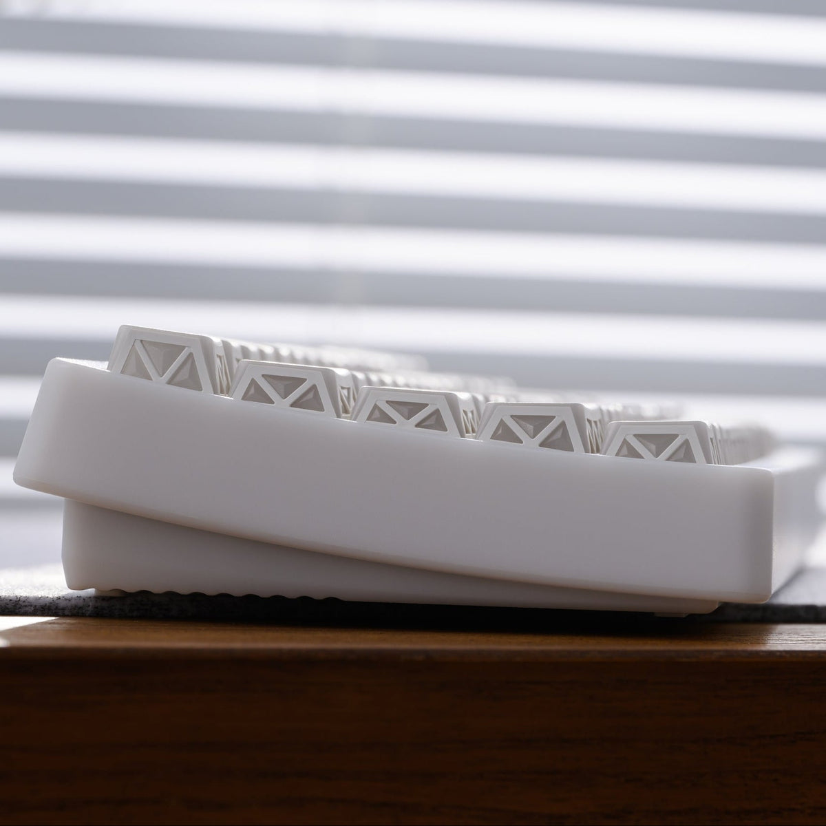 White PBT low-profile keycaps with sculpted prism-row profile viewed from the side