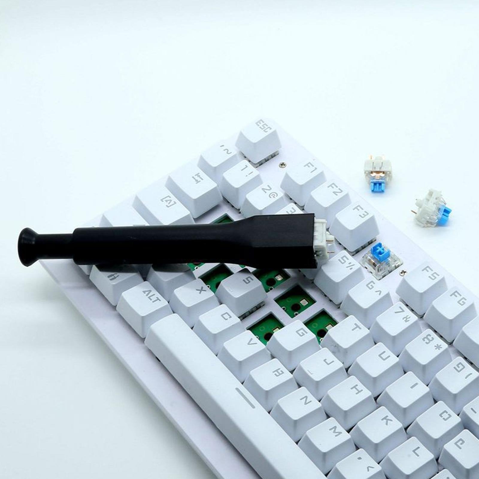 Black switch remover tool pulling between white keyboard keycaps