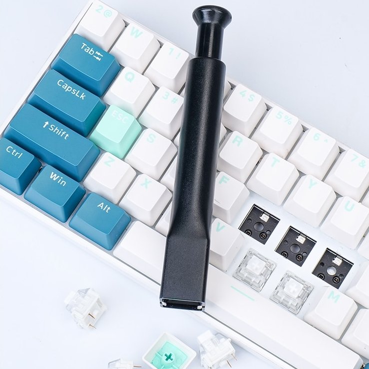Black switch remover tool pressing down on keyboard socket and switch parts