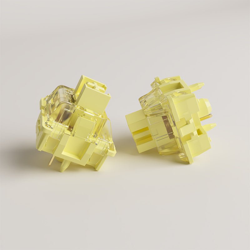 Two cream yellow mechanical switches, side angles with clear housing