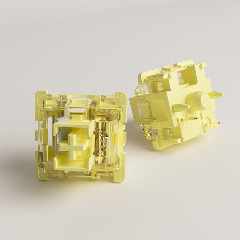 Pair of cream yellow mechanical switches, front and back views