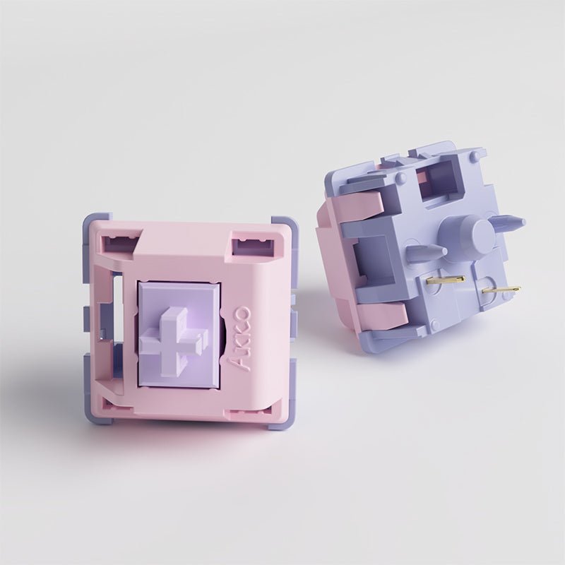 Mechanical keyboard switch, open side view with pastel pink housing and gold pins