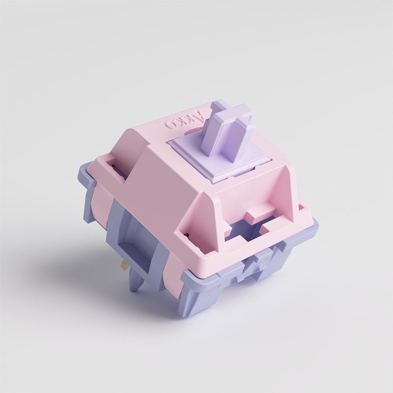 Mechanical keyboard switch, angled view showing lavender stem and pastel pink base