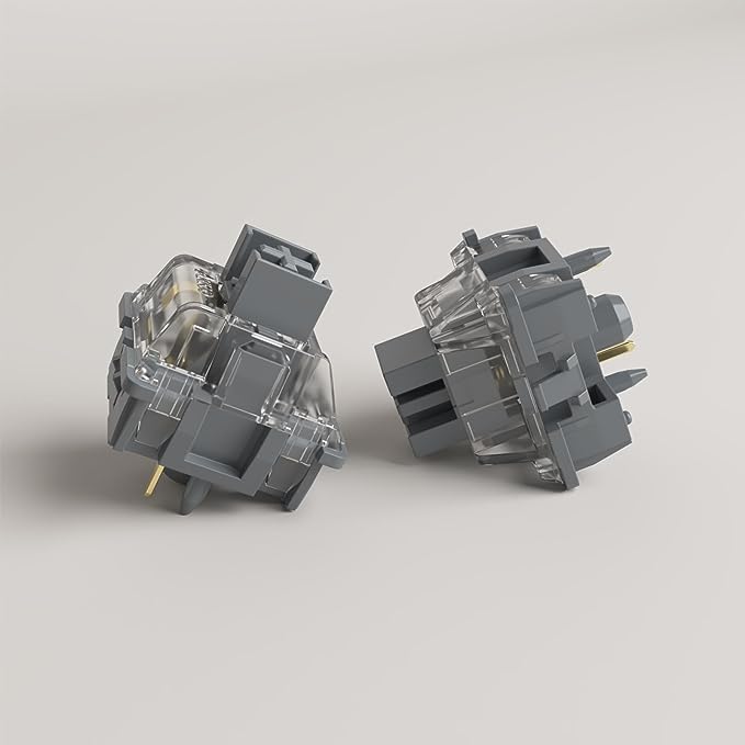 Two mechanical keyboard switches with clear housings and dark gray caps, angled view