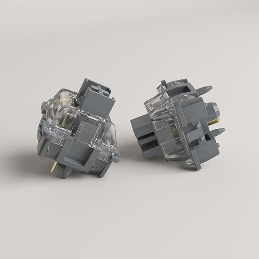 Two mechanical keyboard switches with clear housings and dark gray caps, angled view
