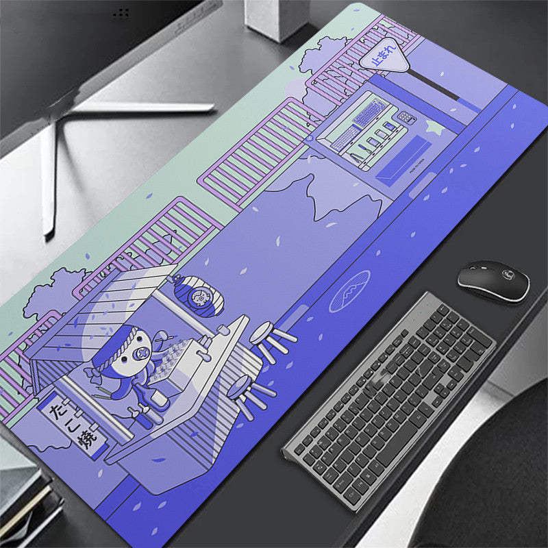 blue desk mat with cartoon design on a desk with keyboard and octopus.
