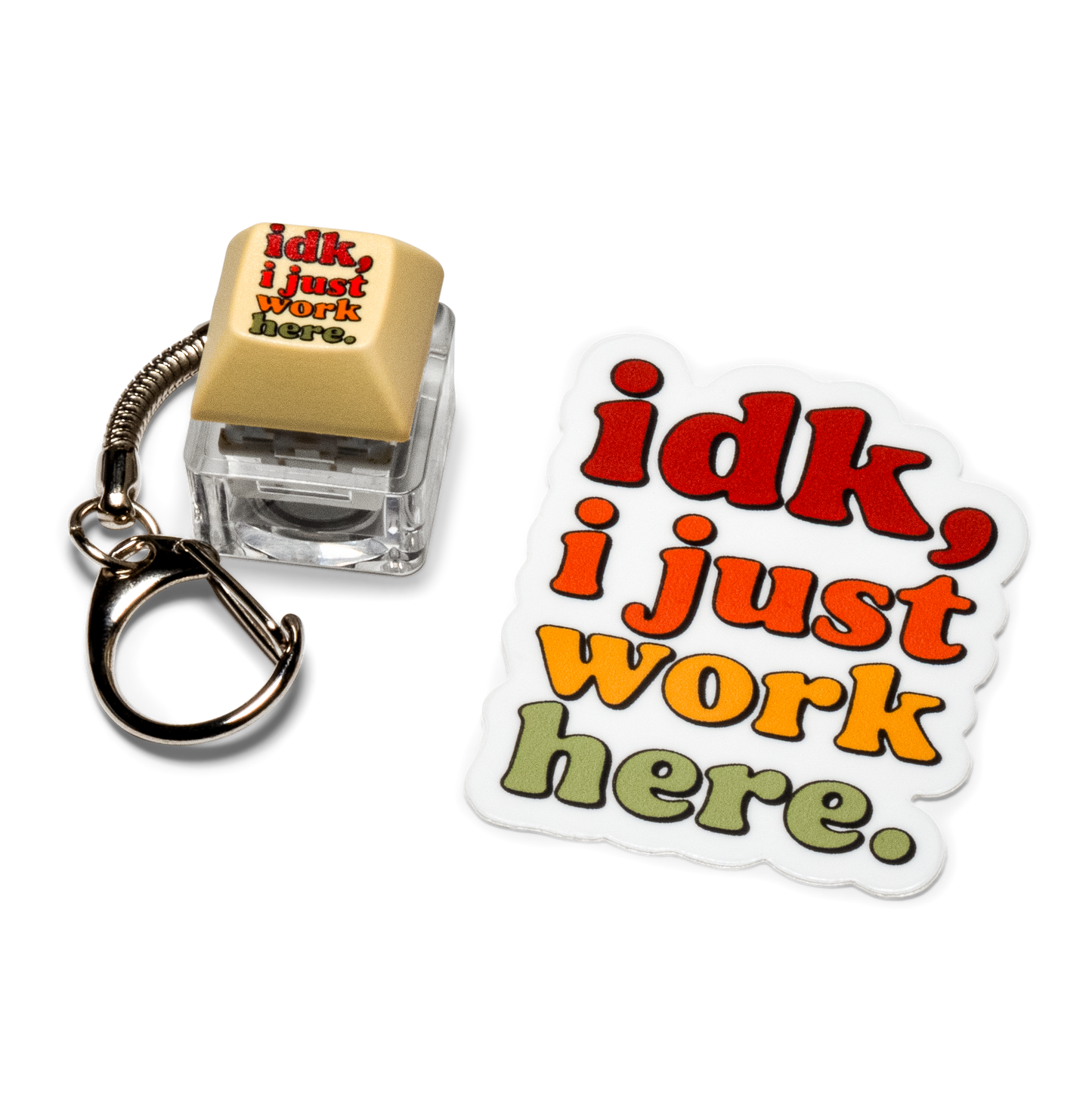 Beige keycap fidget keychain with "idk, I just work here" text and matching sticker.