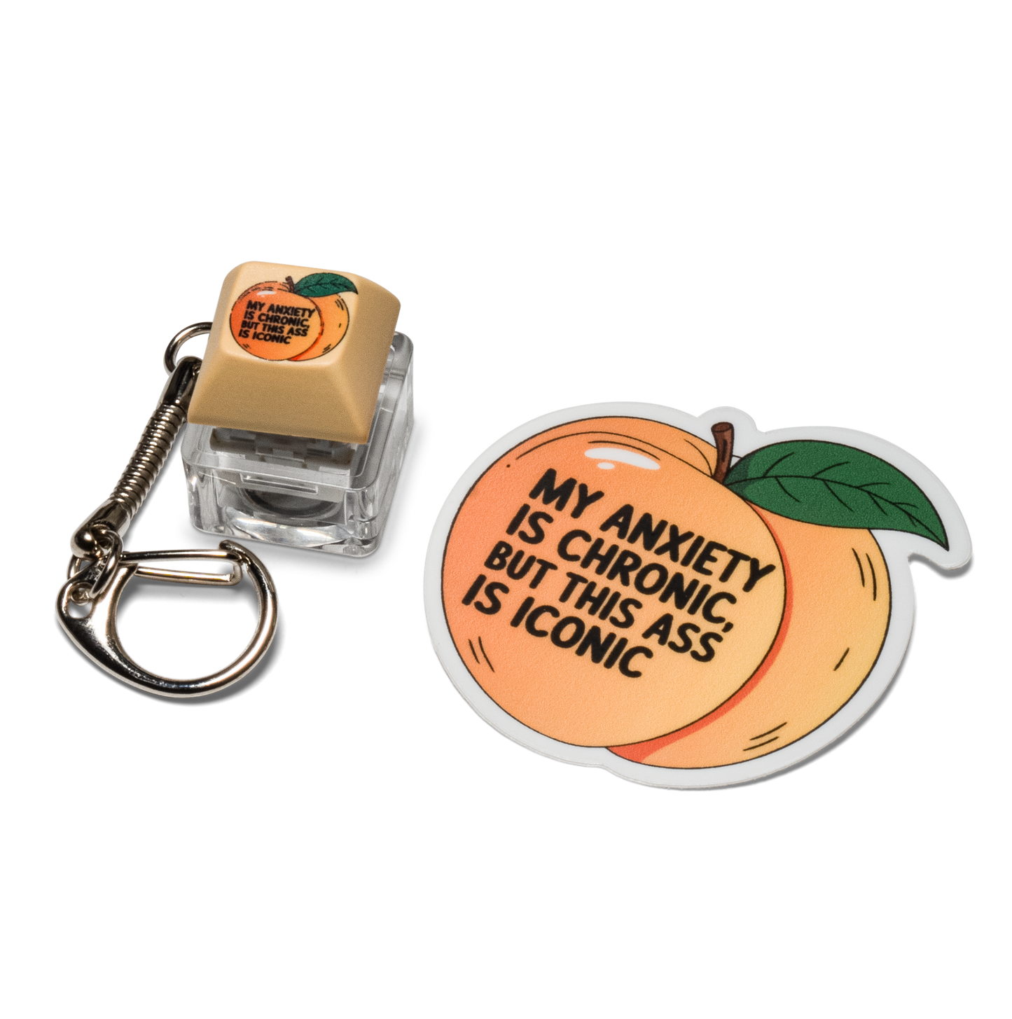 Beige keycap fidget keychain with anxiety peach graphic and round peach sticker.