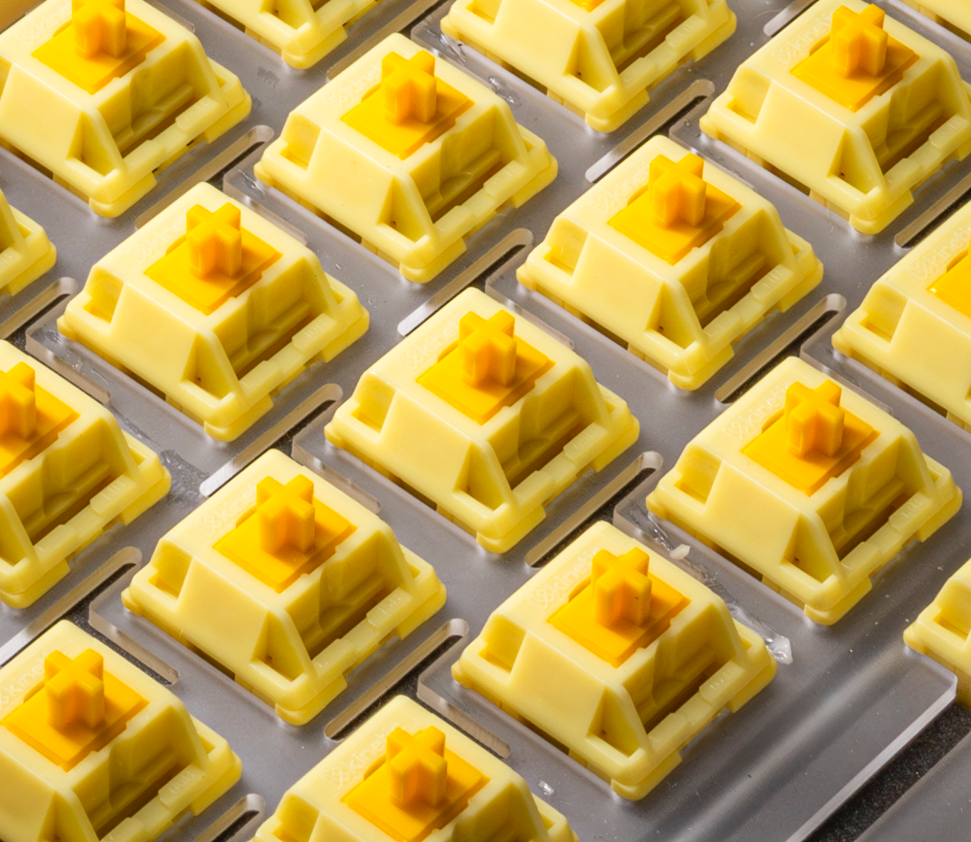 Tray of HMX Butter linear switches with yellow stems in cream sockets