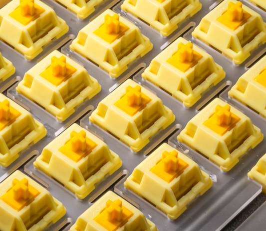 Tray of HMX Butter linear switches with yellow stems in cream sockets