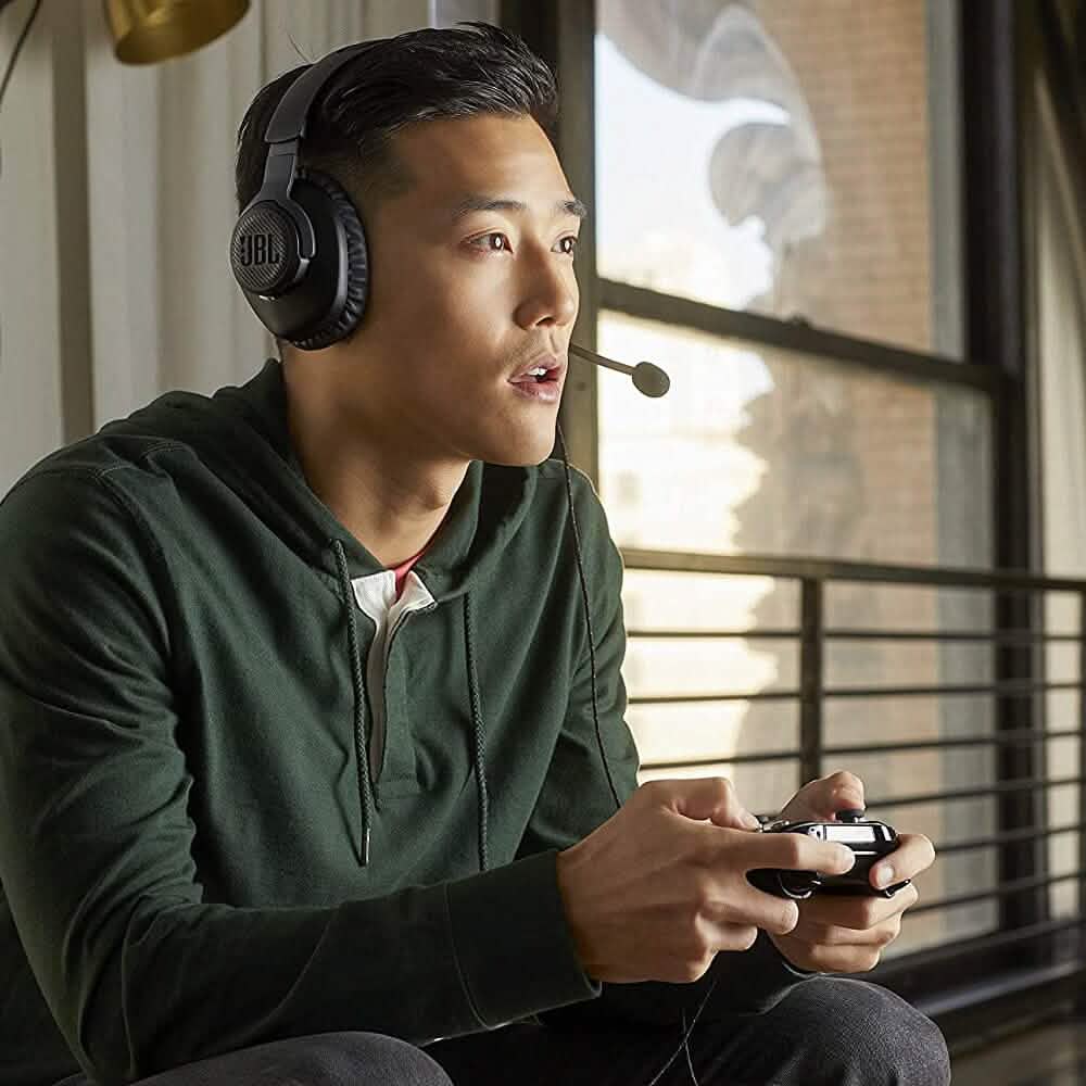 Person wearing JBL Quantum 100 over-ear gaming headphones with boom microphone