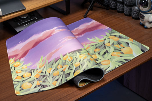 Desk mat showing rolled corner and tropical citrus leaves with orange fruit on lavender