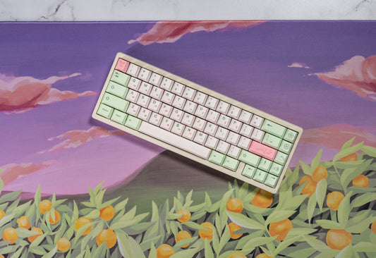 Angled keyboard with pastel keycaps in mint, white, and pink with multicolor legends.