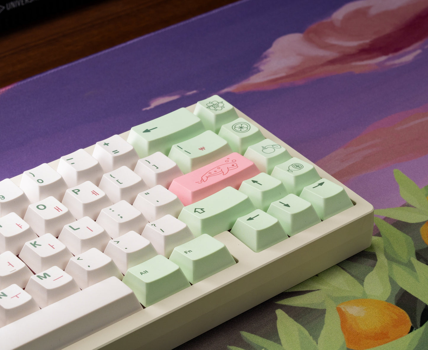 Close-up view of pastel keycaps with mint modifiers and pink accent keys plus symbols.