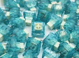 Translucent blue-green switch pieces with metal contacts, close-up