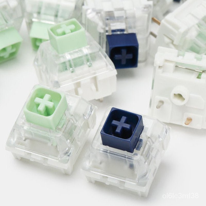Assorted clicky switches with jade-green and navy-blue keycaps in clear housings