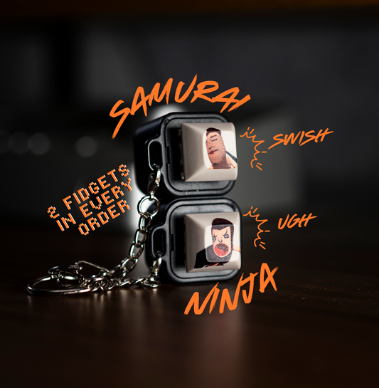 Two black keycap animation fidgets with face graphics and metal keychains