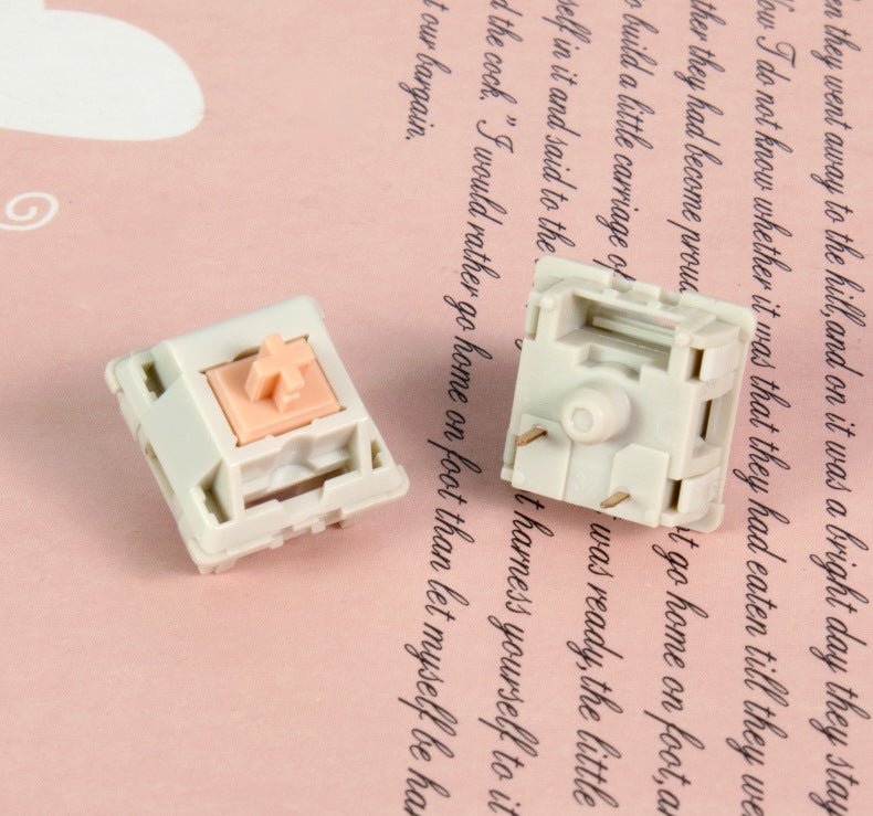 MMD Holy Panda switch parts with peach stem and white housing on a springy assembly