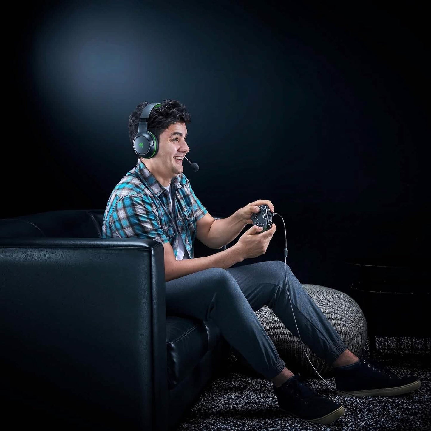 Wired gaming controller in use, held by a player with headset