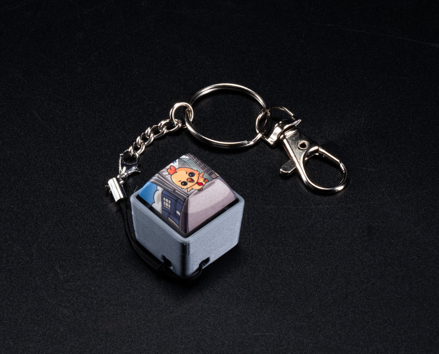 Fidget keychain with silver clasp, light blue keycap charm featuring cartoon Hen face