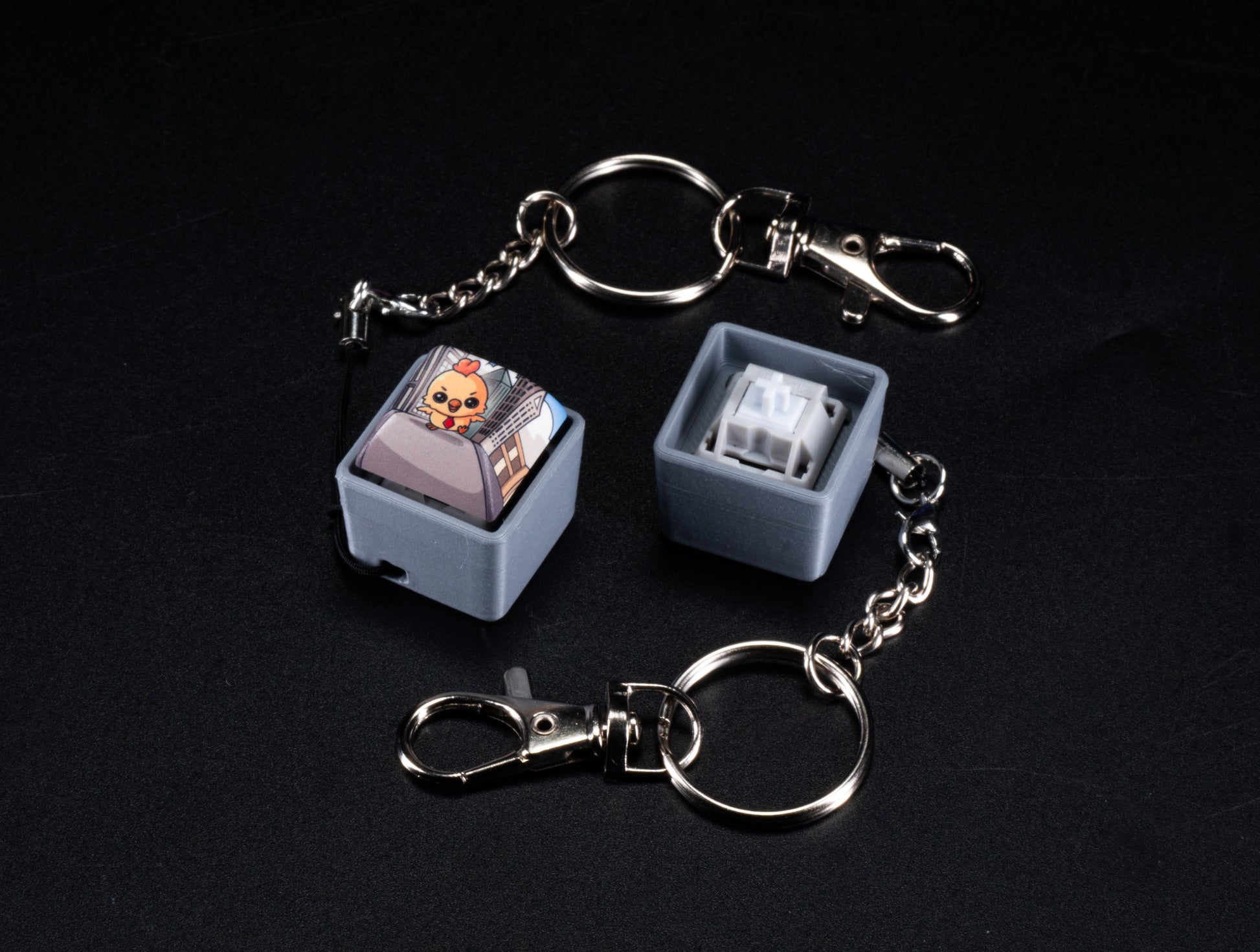 Set of two fidget keychains with silver rings and chains, light blue cartoon Hen keycaps