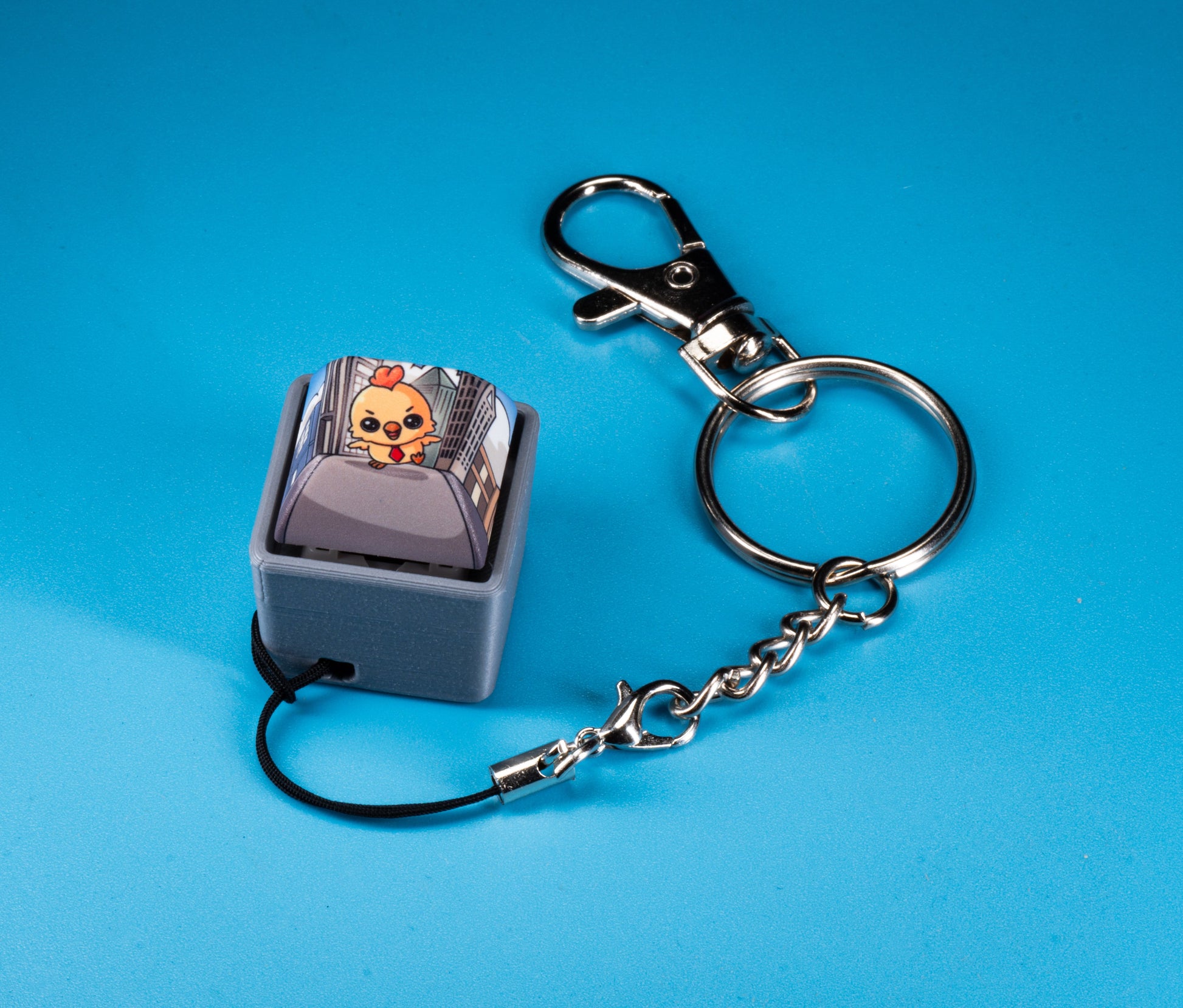 Fidget keychain with silver rings and chain, light blue keycap charm with cartoon Hen