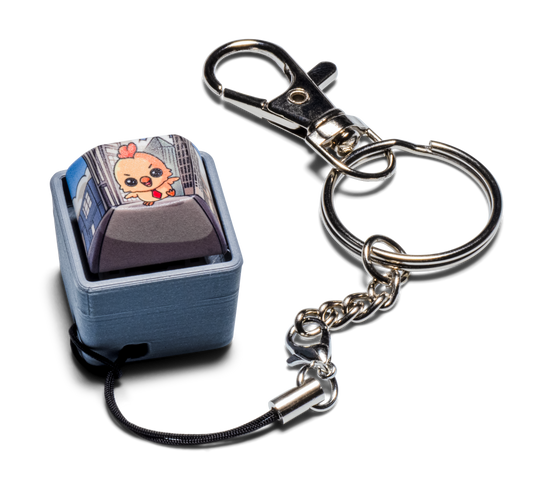Fidget keychain with silver metal clip and chain, light blue keycap charm with cartoon art
