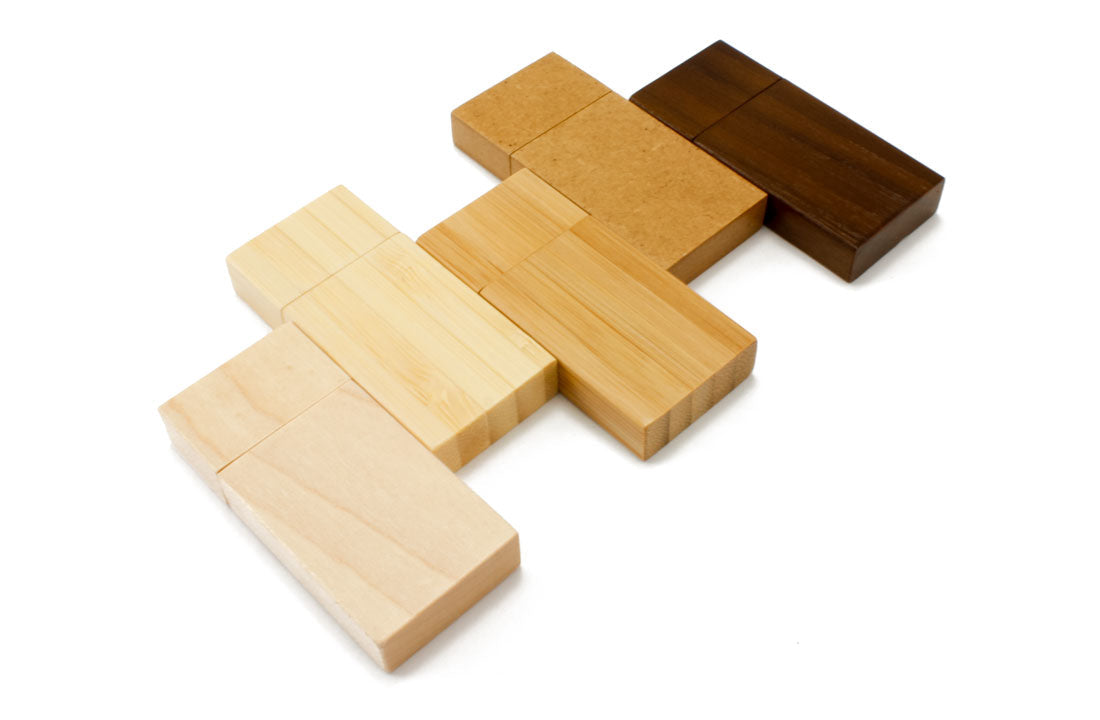 Wooden USB flash drives in mixed light and dark wood blocks, USB ends exposed.