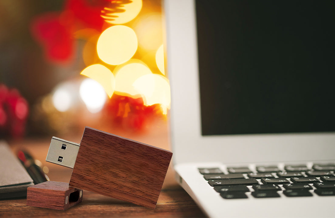 Wood USB flash drive plugged into laptop with silver USB connector