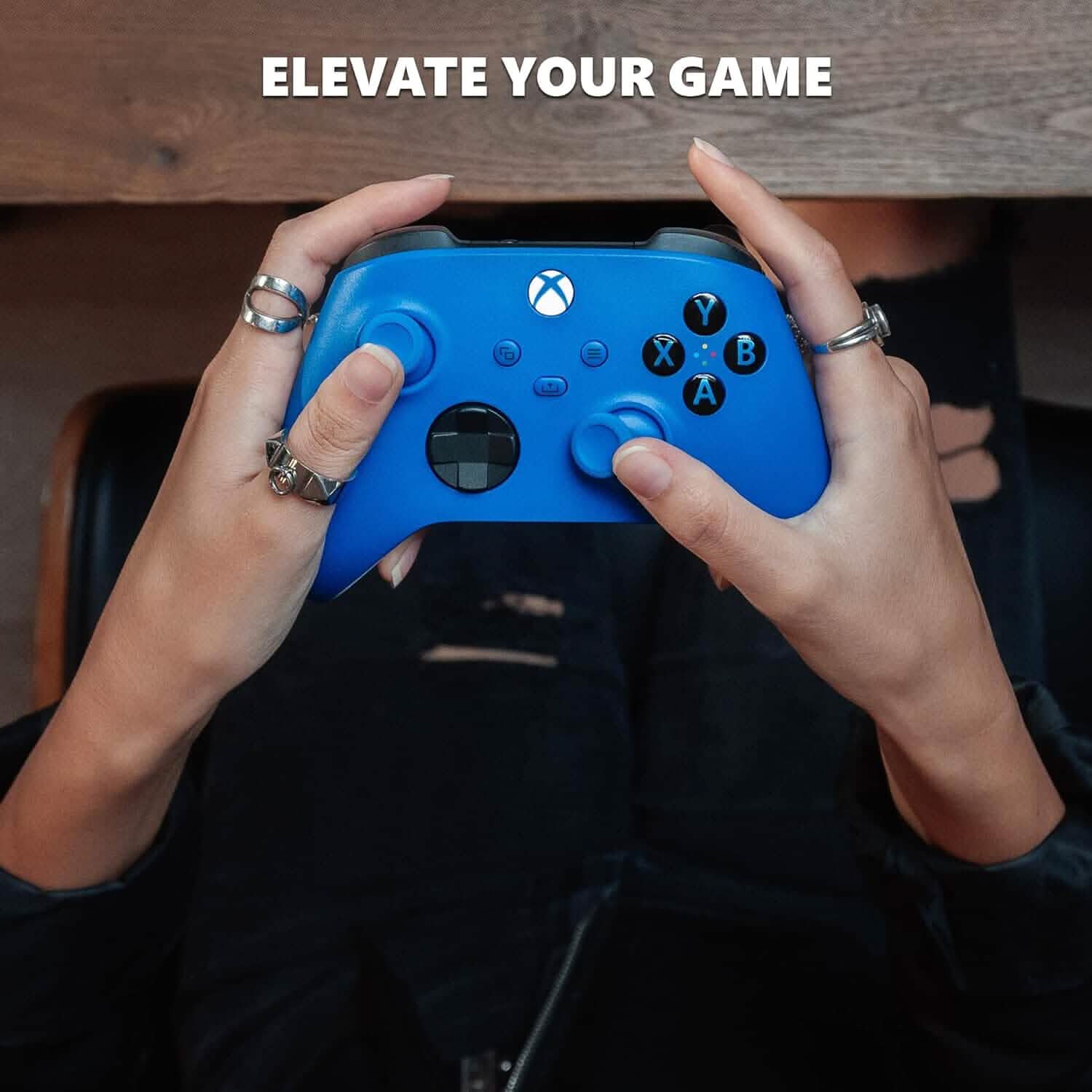 Blue Xbox wireless gaming controller held in hands, showing face buttons and D-pad